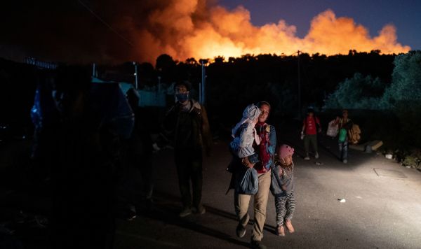Беженцы и мигранты спасаются бегством от пожара в лагере Мориа на острове Лесбос