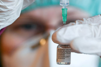 Медицинский работник наполняет шприц вакциной от коронавируса Pfizer-BioNTech