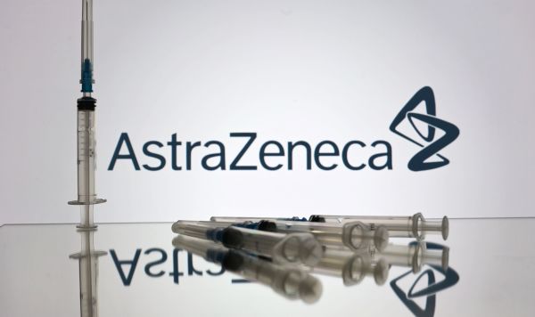 Шприцы на фоне логотипа AstraZeneca