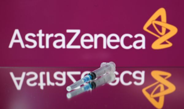 Шприц на фоне логотипа AstraZeneca
